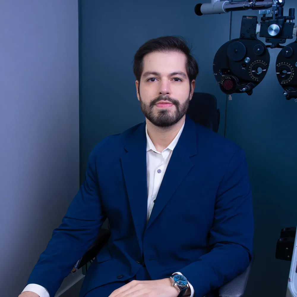 Dr. Leonardo Albuquerque ao lado de equipamento oftalmológico
